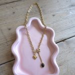 Goudkleurige schakelketting met hartbedel en zwarte bedel