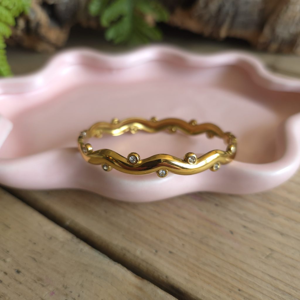 Goudkleurige golvende bangle met ronde steentjes – Studio Glow Jewels
