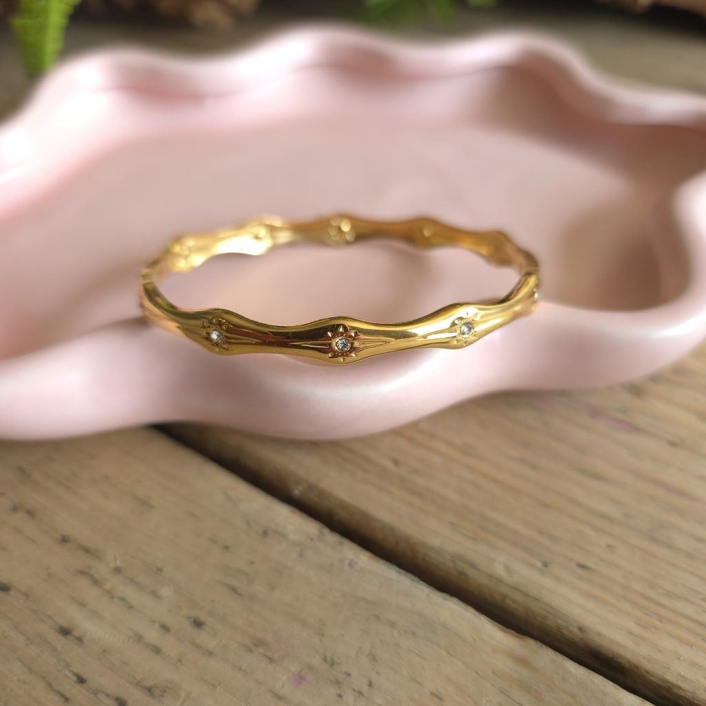Goudkleurige golvende bangle met heldere steentjes – Studio Glow Jewels