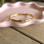 Goudkleurige golvende bangle met heldere steentjes – Studio Glow Jewels