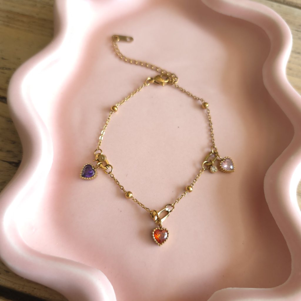 Goudkleurige armband met paarse, roze en rode hartjes – Studio Glow Jewels