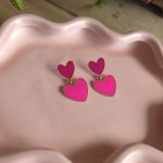 Goudkleurige oorbellen met dubbele felroze hartjes – Studio Glow Jewels