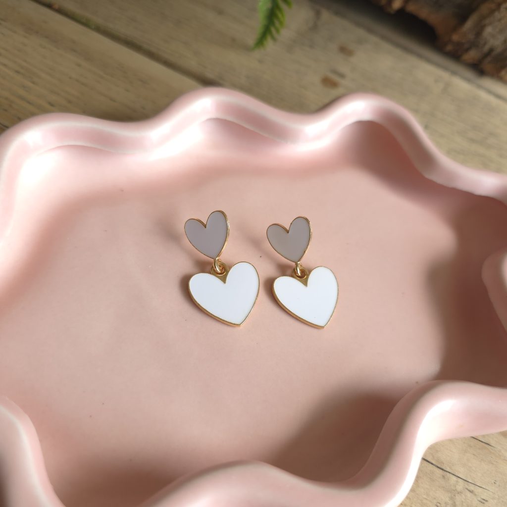 Goudkleurige oorbellen met dubbele witte hartjes – Studio Glow Jewels
