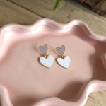 Goudkleurige oorbellen met dubbele witte hartjes – Studio Glow Jewels