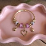 Goudkleurige bedelarmband met roze kralen en hartje – Studio Glow Jewels