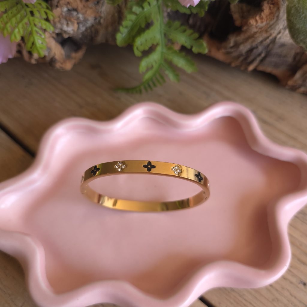 Goudkleurige bangle met zwarte klavers en fonkelende bloemdetails – Studio Glow Jewels