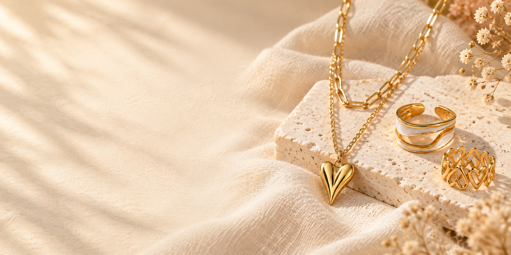 Gouden hartketting en ringen op warme lichte achtergrond – Studio Glow Jewels